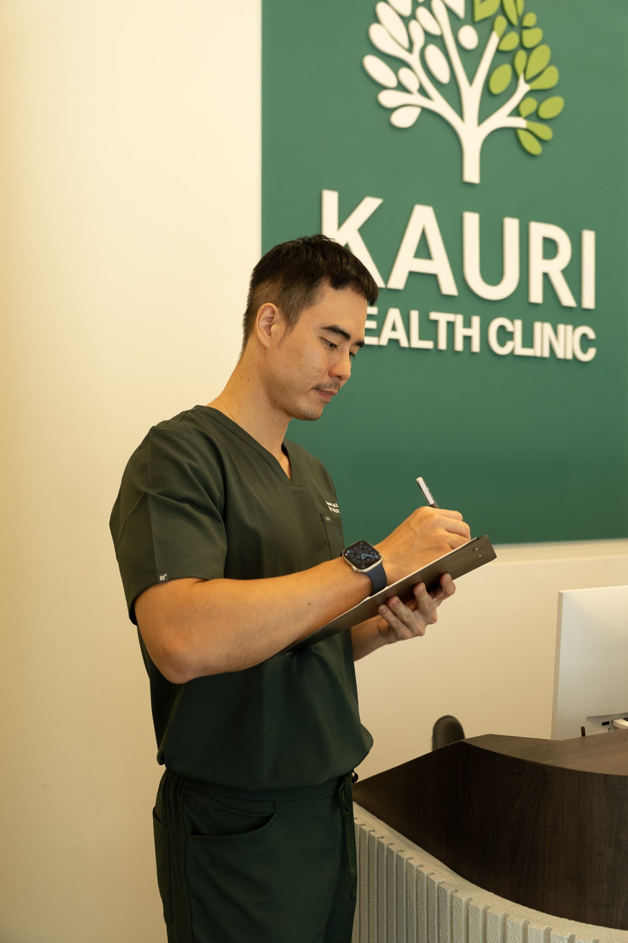 A Kauri clinician reviewing notes at the clinic reception